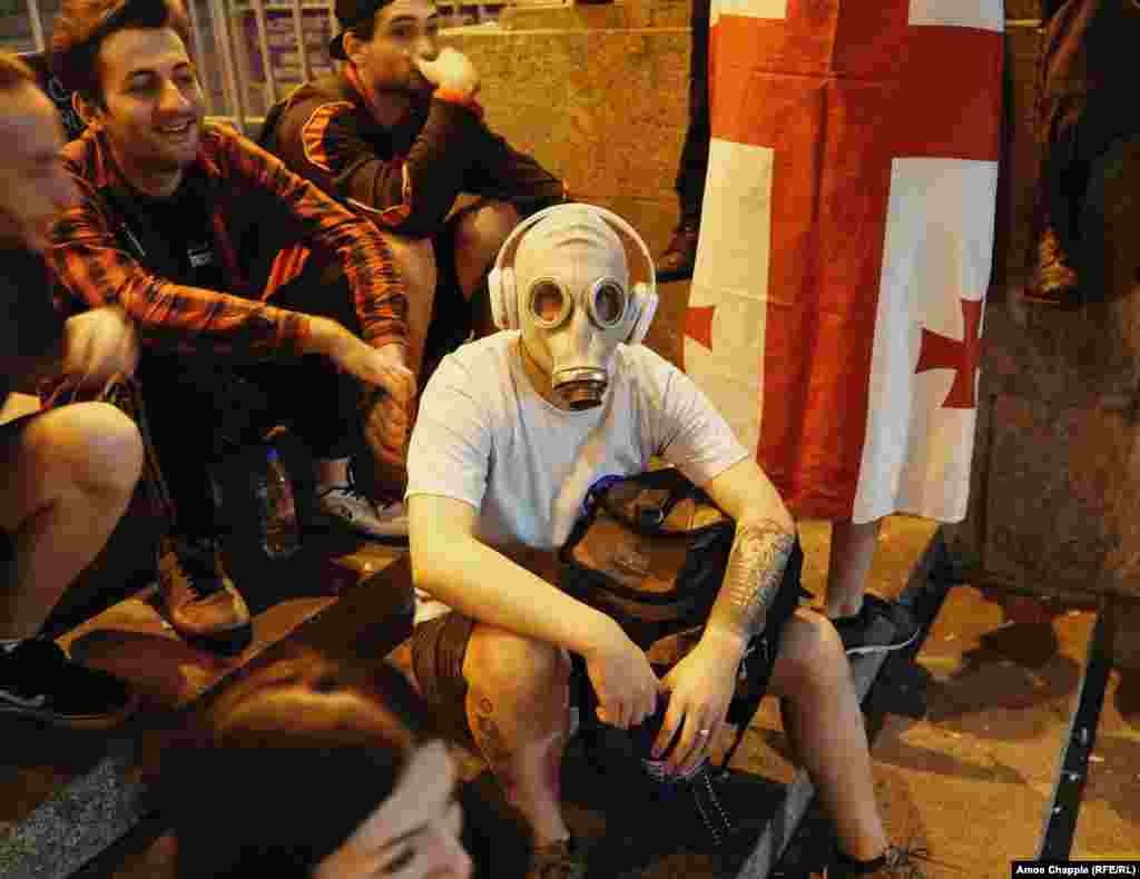 A protester in Tbilisi wears a gas mask in the early hours of June 22. Hundreds remained in the streets for a second night, following a larger and more violent protest on June 20 when police used tear gas, rubber bullets, and water cannons against the crowds.