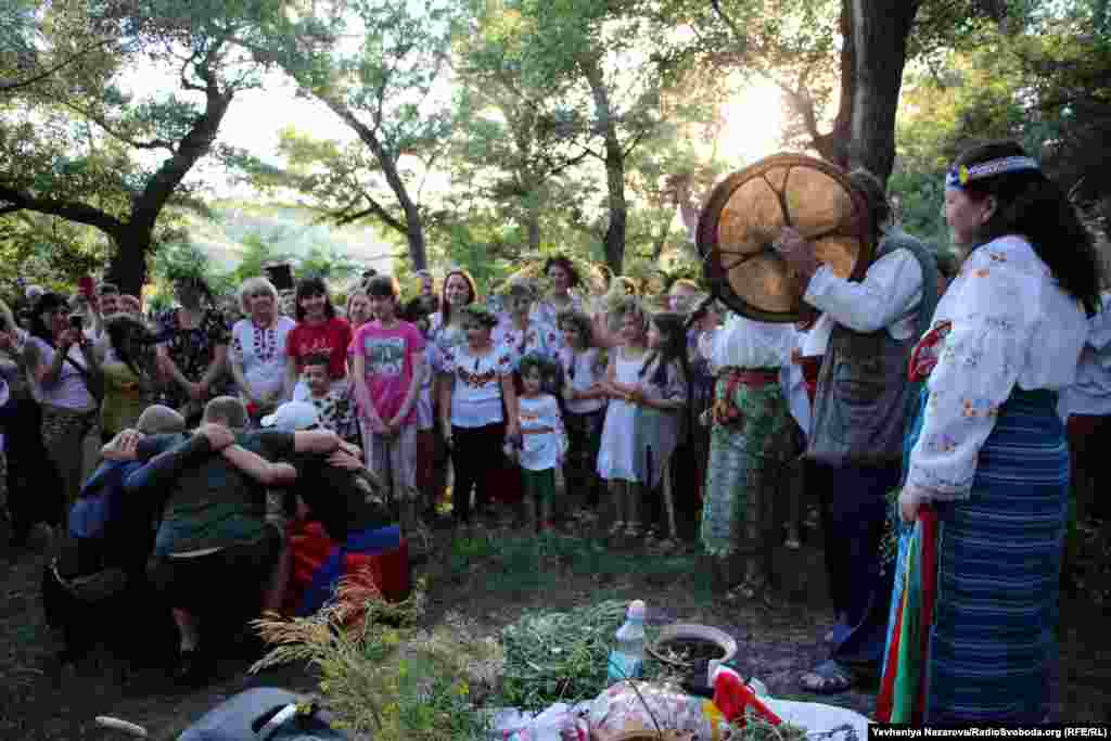 Men dance to the rhythm of a drum.&nbsp;