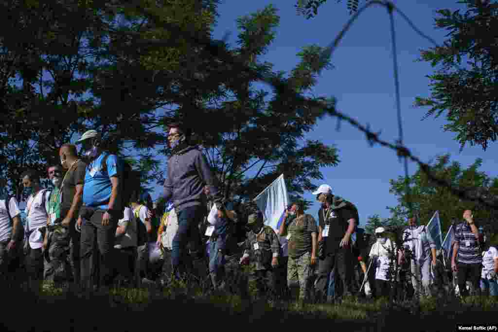 Bosnians, some of them survivors of the 1995 Srebrenica massacre, walk through a mountain area near Crni Vrh on July 8 during a peace march recreating the path take 25 years ago by people trying to escape advancing Serb forces. The event commemorates the more than 8,000 Bosnian Muslim men and boys who perished 25 years ago during 10 days of slaughter after Srebrenica was overrun by Bosnian Serb forces on July 11, 1995, during Bosnia&#39;s 1992-95 war. (AP/Kemal Softic)