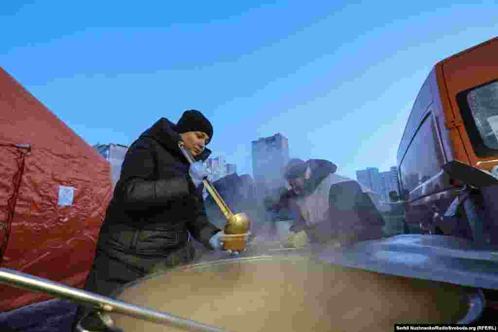 Жителі Києва приходять по гарячу їжу з термосами та пластиковими ємностями