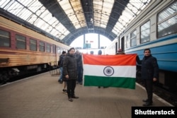 Two Indian men hold their nation's flag in Lviv in March 2022 before fleeing from Ukraine. Before Russia's 2022 invasion some 22,000 foreign workers were registered in Ukraine.