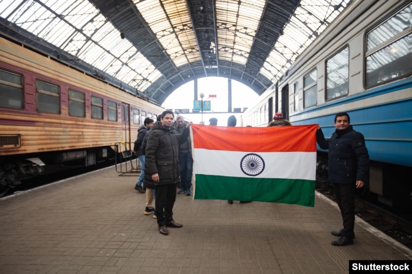 Dy punëtorë indianë mbajnë në duar flamurin e shtetit të tyre në Lviv në mars të vitit 2022 para se të largohen nga Ukraina. Para nisjes së pushtimit rus të Ukrainës më 2022, afër 22.000 punëtorë të huaj ishin të regjistruar në Ukrainë.