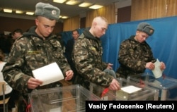 Soldiers of Ukraine's presidential regiment cast their votes at a polling station in Kyiv on October 31, 2004.