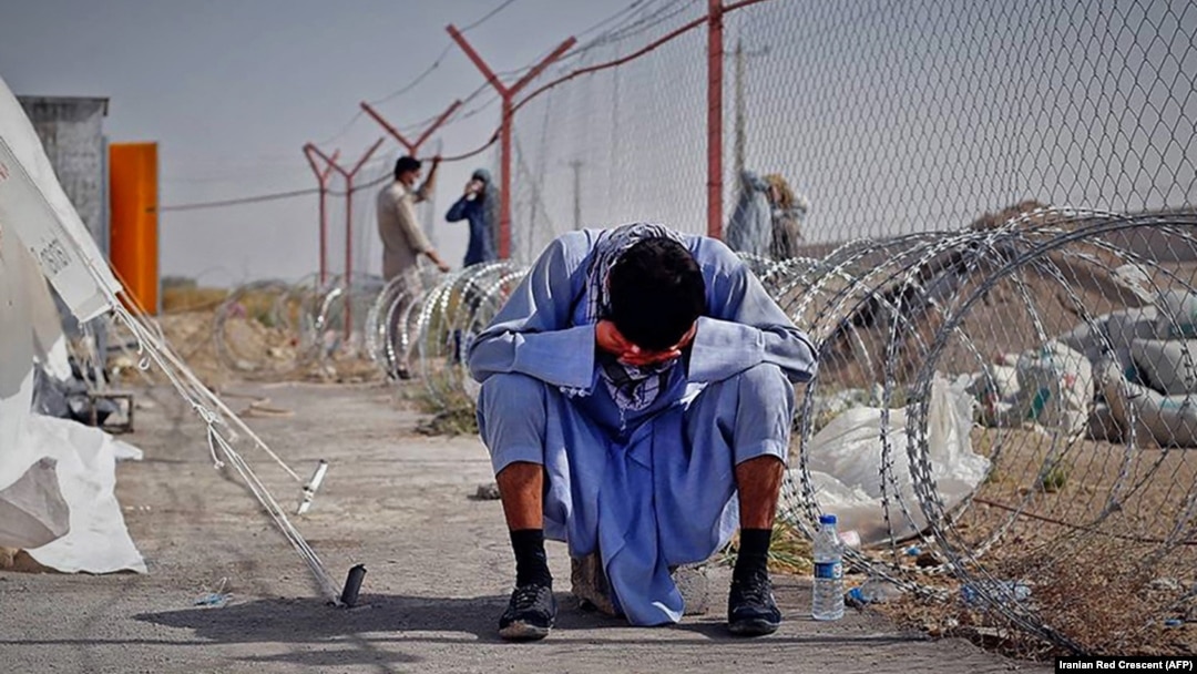 An Afghan man sits at the border between Afghanistan and the southeastern Iranian province of Sistan-Baluchestan.