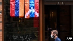 ARMENIA -- A man walks past a shop decorated with flags of Armenia and Nagorno-Karabakh in Yerevan, October 6, 2020