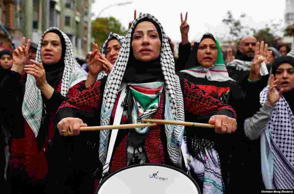 Učesnica protesta u Berlinu u Nemačkoj, lupa u bubnjeve, ogrnuta palestinskom maramom, 6. oktobar&nbsp; 2024.