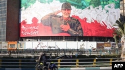 Iranci voze motocikl pored ogromnog bilborda sa slikom bivšeg komandanta Islamske revolucionarne garde Kasemom Sulejmanijem u Teheranu, 31. decembar 2025.