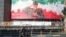 Iranians ride a motorbike past a huge banner of former IRGC commander Qasem Soleimani in Tehran in December.