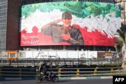 Огромный баннер с изображением Касема Сулеймани, бывшего командующего спецподразделением "Аль-Кудс" в составе КСИР, в преддверии шестой годовщины его ликвидации ВВС США в Ираке. Площадь Валиаср в Тегеране, 31 декабря 2026 года