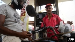 د ارشیف انځور کې وینئ چې یو موټر سایکل چلوونکی د تېلو په پمپ کې ولاړ دی. 