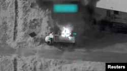 Smoke rises from a vehicle following a US strike in Iran.