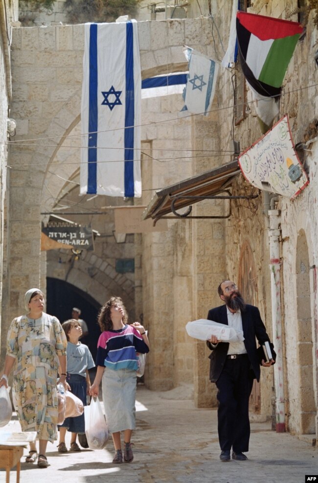 نسخهٔ کامل عکس بالای متن: یک خانواده یهودی در حال عبور از کوچه‌ای در شهر قدیمی اورشلیم، ۱۵ سپتامبر ۱۹۹۳