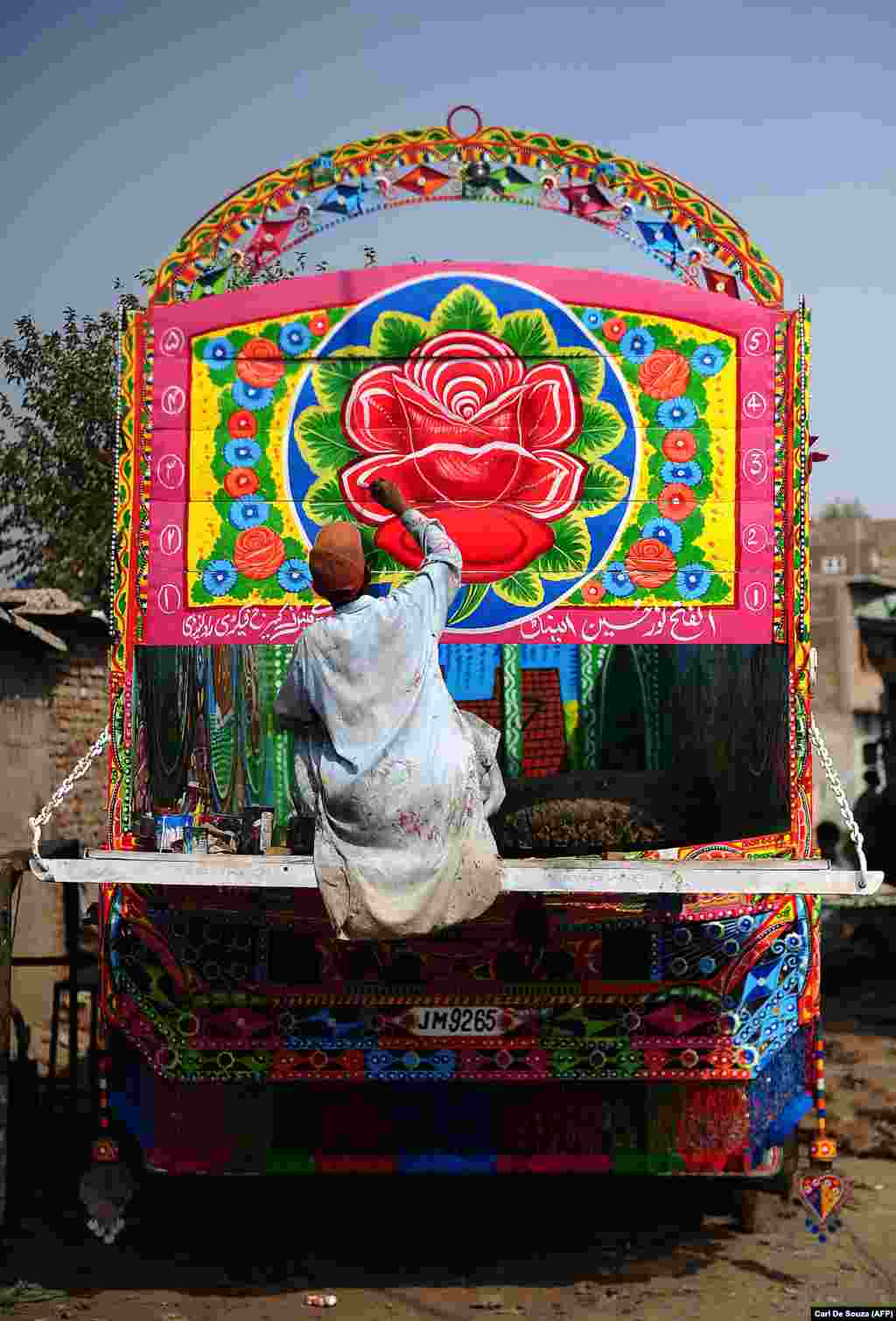 A truck painter adds the finishing touches to the bodywork of a truck in Rawalpindi. The trucks of Pakistan may be known for color, but they remain hard-working vehicles.&nbsp;