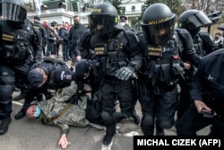 Police detain a counterprotester outside the Russian Embassy in Prague during an anti-Russia protest on April 18.