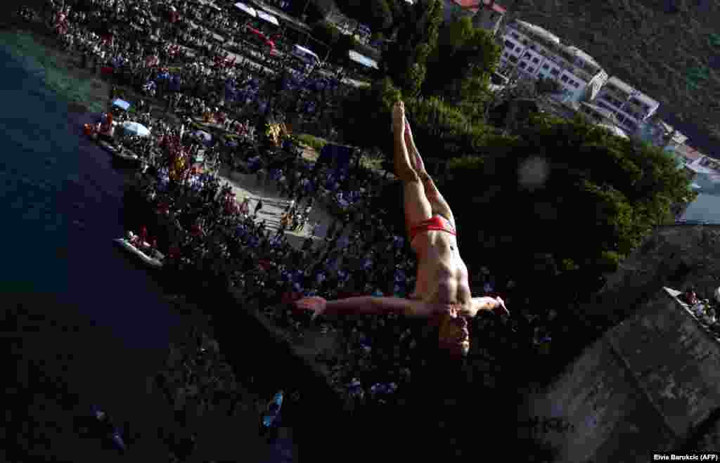 A Bosnian high diver takes off from the Old Bridge that straddles the Neretva River in Mostar during the 452th traditional diving competition on July 29. (AFP/Elvis Barukcic)