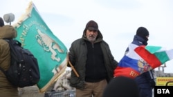 Мъж развява знамена пред паметника на връх Шипка, 3 март 2026 г.