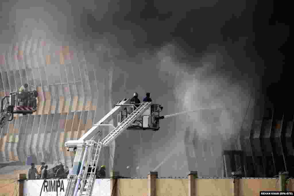 Firefighters try to extinguish a blaze that broke out at the Rimpa Plaza commercial building in Karachi, Pakistan, on December 3.&nbsp;