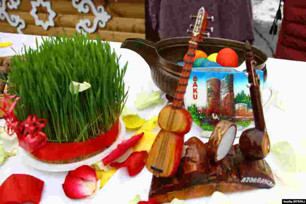 Азәрбайҗан өстәлендә Нәүрүз бәйрәме уңаеннан буялган йомырка, шыттырылган бодай, милли уен коралы сыны һәм башкалаларының символы сурәте