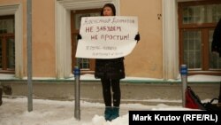 Участница акции памяти активиста партии «Другая Россия» Александра Долматова с плакатом.