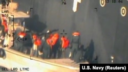 An image released by the Pentagon, which it says was taken from a U.S. Navy helicopter in the Gulf of Oman on June 13. It shows personnel that the Pentagon says are Iranian removing an unexploded limpet mine from the Kokuka Courageous, a Japanese-owned commercial tanker.