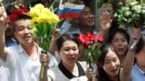 Pxenyanda insanlar Şimali Koreya lideri Kim Çen In və Rusiya prezidenti Vladimir Putini daşıyan kortejə əl yelləyirlər.