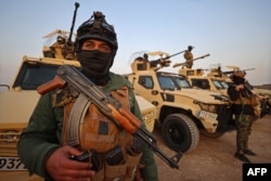 Members of the Popular Mobilization Forces stand guard at a military base near the Iraqi-Syrian border in Al-Qaim. (file photo)