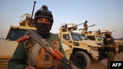 گروهی از نیروهای حشد الشعبی مستقر در نزدیکی یک پایگاه نظامی عراق در نزدیکی مرز با سوریه