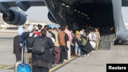 Посадка беженцев в американский транспортный самолет C-17 в аэропорту Кабула.