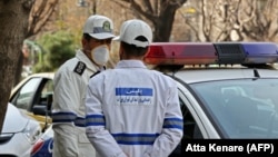 Iran -- Emergency first responders wearing protective masks stand along a street in Tehran, February 24, 2020