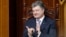 Ukrainian President Petro Poroshenko applauds during a session of parliament in Kyiv on June 19, during which deputies endorsed his nominations for key government posts. 