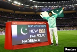 Arshad Nadeem își sărbătorește noul record olimpic și medalia de aur cu care se va întoarce în Pakistan.