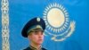 Казак жоокер мамлекеттик байрактын жанында. 