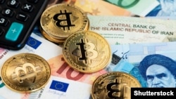 Bitcoin coins pictured with euros and Iranian rials (illustrative photo)