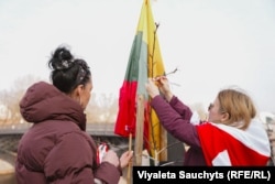 Беларусы каля Сейму Літвы на «Алеі беларускай дэмакратыі» павязалі бел-чырвона-белыя стужкі на дрэвы. Вільня, 25 сакавіка 2026 году