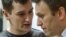 Russian opposition leader Aleksei Navalny (right) listens to his brother and co-defendant Oleg in a Moscow court in December 2014.