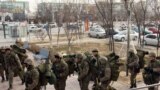 Вооруженное и по-зимнему экипированное подразделение внутренних войск направляется в здание "Казахтелекома" с тыльной стороны. Актау, 21 декабря 2011 года. 
