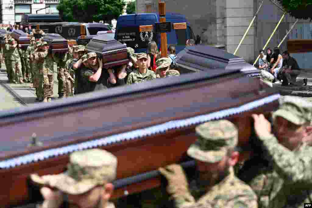 Soldiers carry coffins during a funeral ceremony in Lviv for 12 Ukrainian servicemen and prisoners of war who died while in Russian captivity.