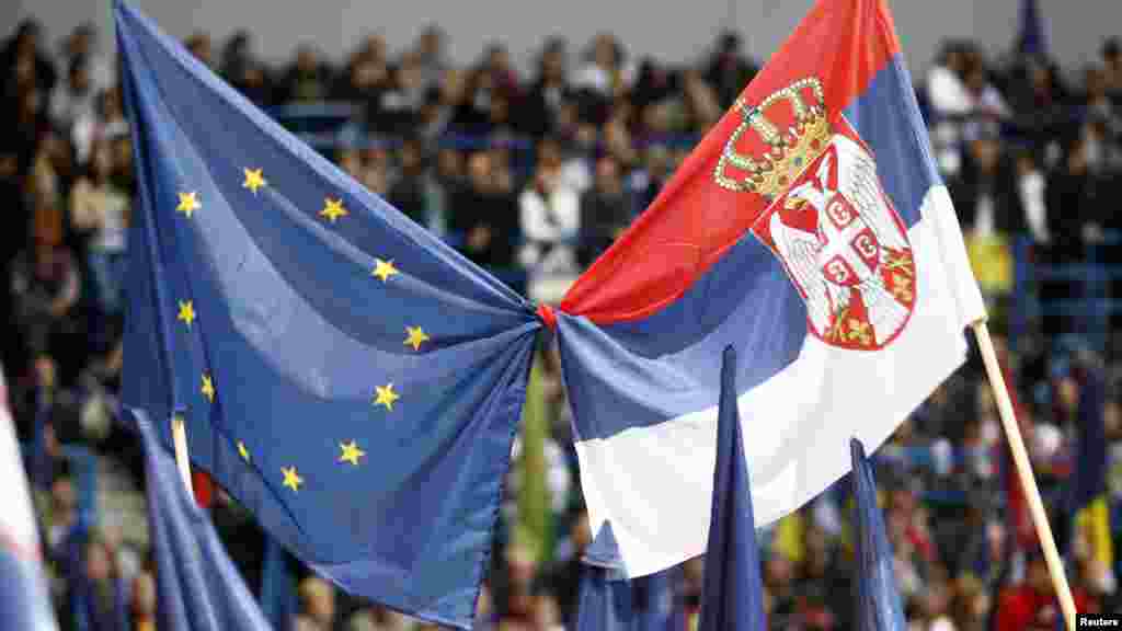 Tadic supporters wave Serbian and EU flags at a May 17 rally. Tadic says a third term would be dedicated to European integration and economic development. (REUTERS/Ivan Milutinovic)