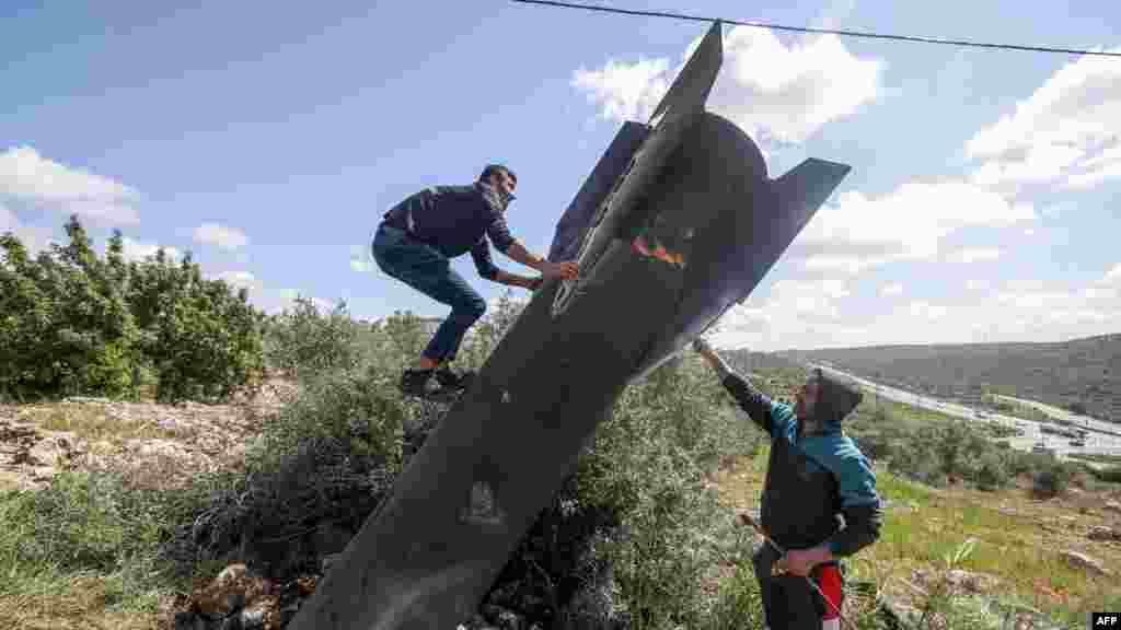 Palestinac se penje po ostacima iranske rakete koji su pali na izraelski okupiranu Zapadnu obalu 24. marta.