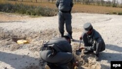 پولیس افغان در حال حنثی کردن بمب کارگذاری شده توسط مخالفین در ولسوالی چهار درهء ولایت کندز.