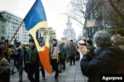 „Huligani” pașnici privind spre balconul Operei din Timișoara unde se aflau vorbitorii, față în față cu Catedrala ce se vede în imagine. Imagine din 21 decembrie 1989.