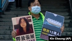 Një aktivist në Hong Kong mban në dorë fotografinë e gazetares së burgosur, Zhang Zhan, 28 dhjetor, 2020.
