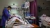 An Iranian nurse checks on COVID-19 patients at a hospital amid a surge in cases in Tehran. 