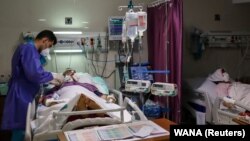 An Iranian nurse checks on COVID-19 patients at a hospital amid a surge in cases in Tehran. 