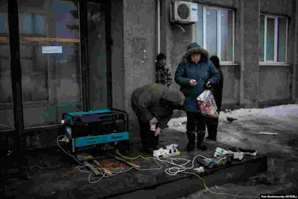 Residents charge their mobile phones from a diesel generator.