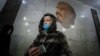 A woman wearing a protective face mask walks in Moscow's subway.