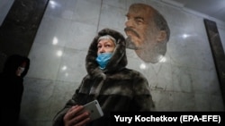 A woman wearing a protective face mask walks in Moscow's subway.