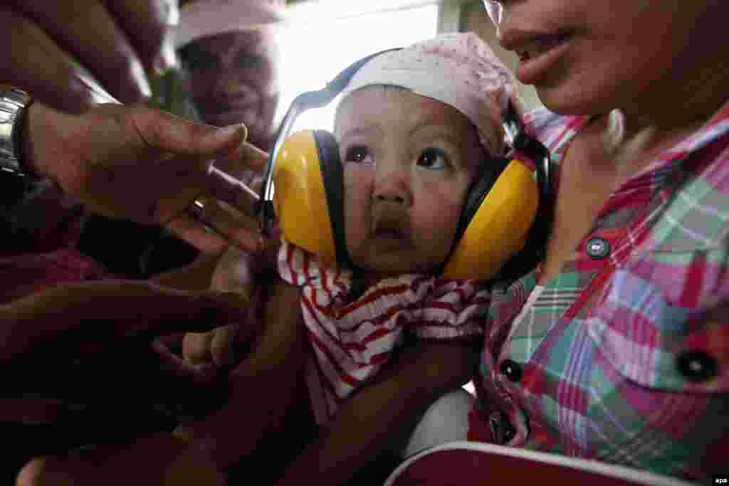 Majka sa bolesnim djetetom u vojnom avionu, Guiuan, 11. novembar 2013. Foto: EPA / Dennis M. Sabangan 