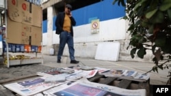 Muškarac prolazi pored kioska na kojem se prodaju novine s likom iranskog vrhovnog vođe, ajatolaha Alija Hamneija, izloženog u Teheranu 18. februara 2026. godine.