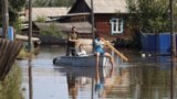 RUSSIA -- Local residents sail a boat in the flood-hit settlement of Oktyabrsky in Irkutsk Region, Russia July 5, 2019. 